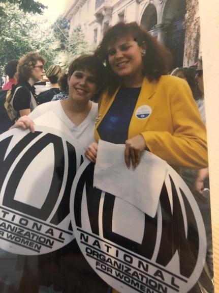 A group of women holding signs
Description automatically generated
